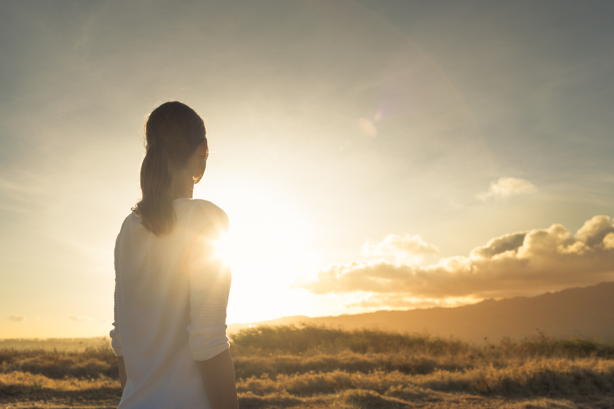 Woman looking at the sunset. Location Hawaii.