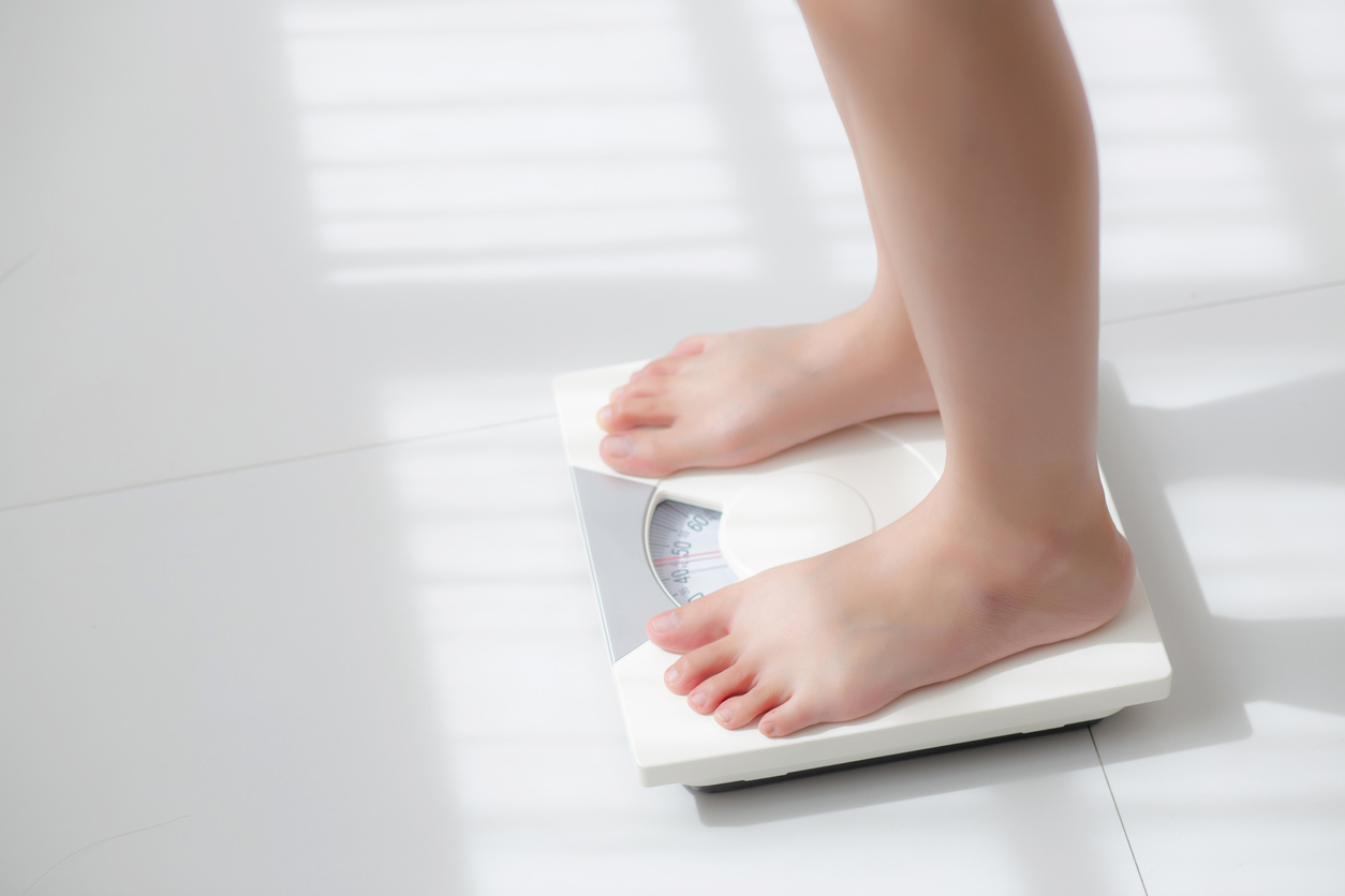 生活風格，女性赤腳站在體重體脂計上量體重